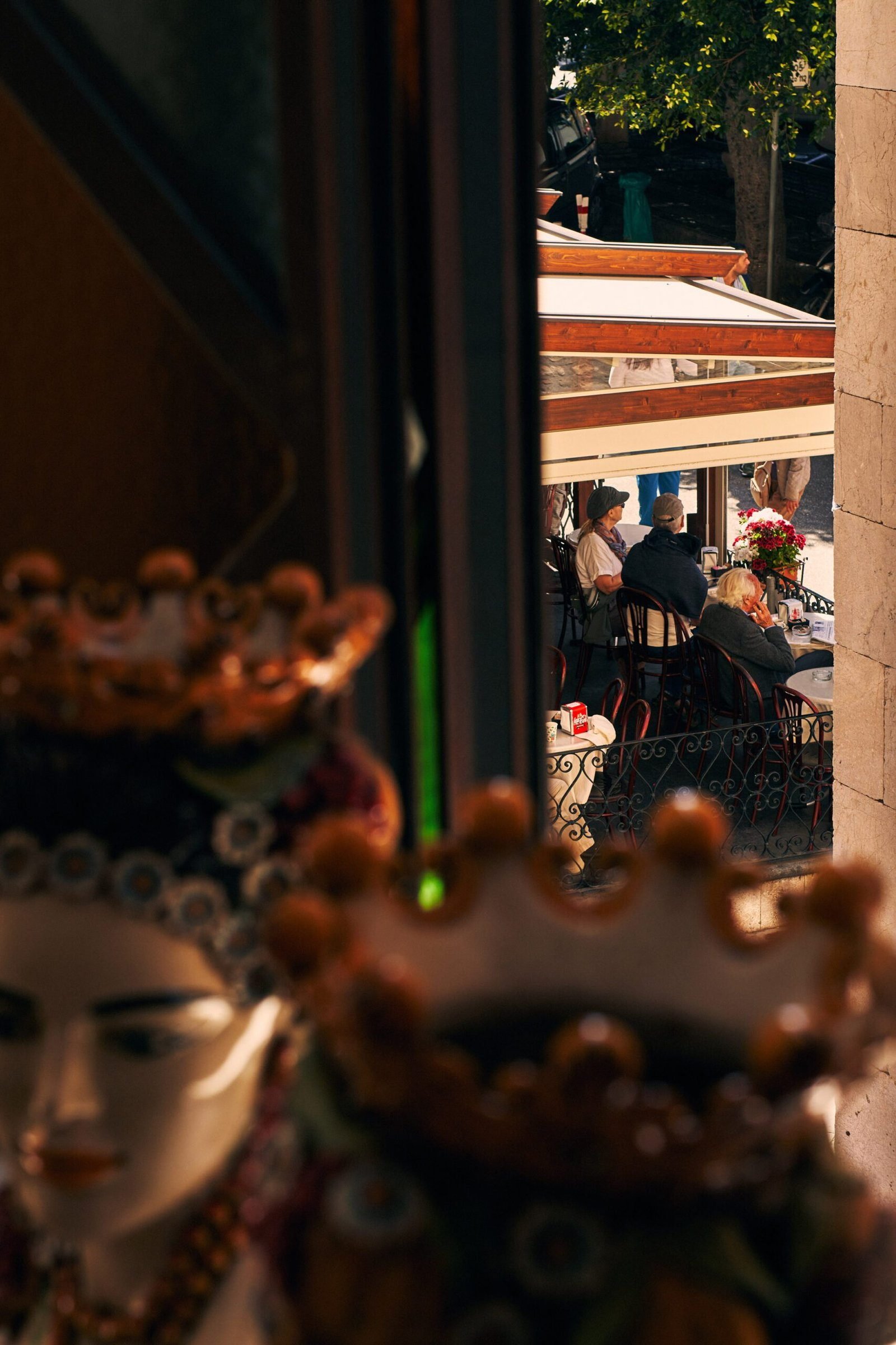 Guests at a pavement café in Taormina, framed by hand-painted Sicilian ceramics