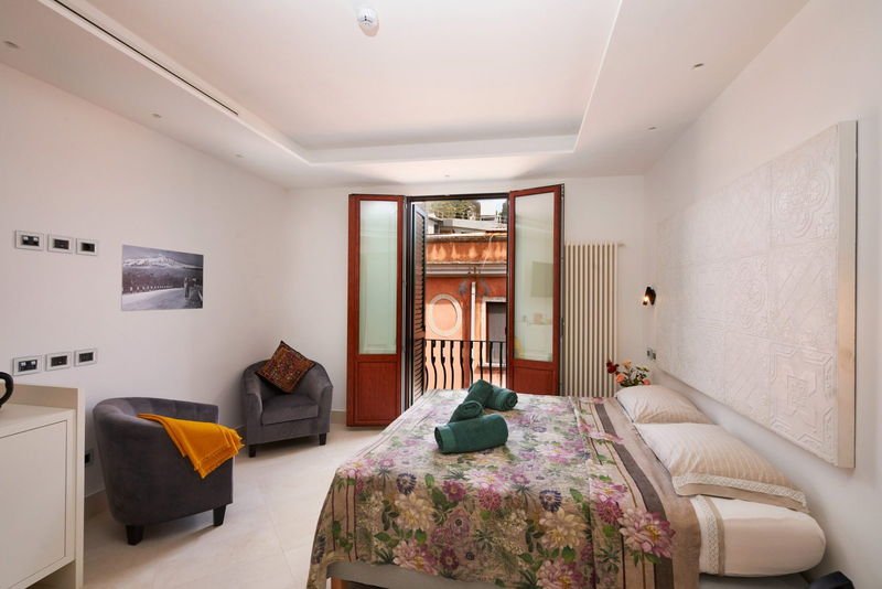 Deluxe Suite with armchairs and doors opening onto the balcony