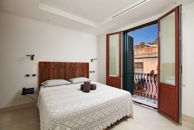King Standard room with walnut headboard and open balcony doors