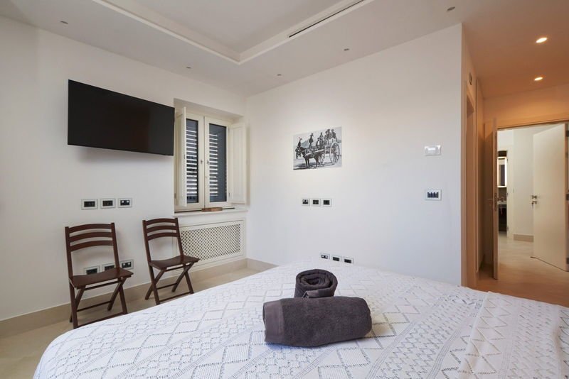 King Standard bedroom with shuttered window and television