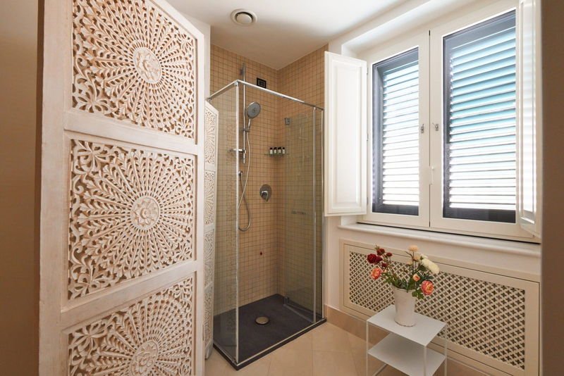 Shower behind a carved privacy screen