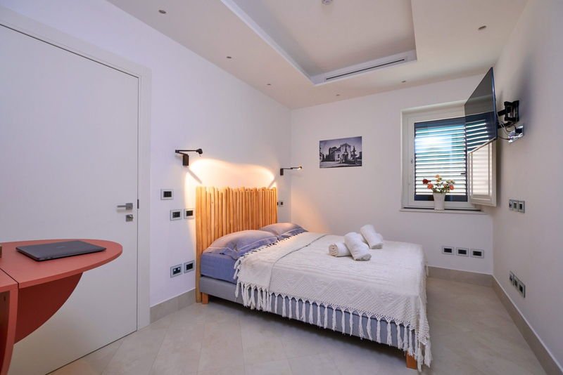 Queen Standard room with a driftwood headboard and shuttered window